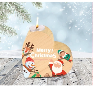 Close-up of heart-shaped pine candle holder with festive Christmas patterns and warm tea light