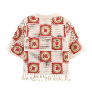 Detail view of the bohemian crochet knit pattern and fringe tassels on the back of the top