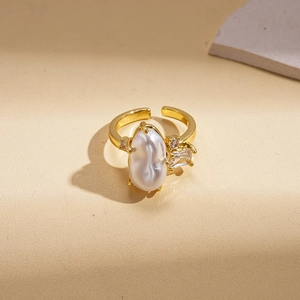 Detailed macro view of baroque pearl and zircon inlay on a double-layer golden open ring