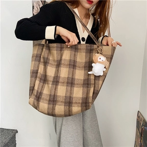 Detailed view of a large capacity brown plaid woolen tote bag with a cute white plush charm
