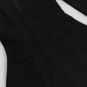 Detailed macro view of the smooth black woven fabric and invisible zipper on dress