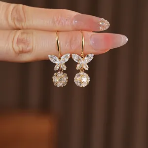 Eleganti orecchini a farfalla dorati con zirconi scintillanti e perle di cristallo