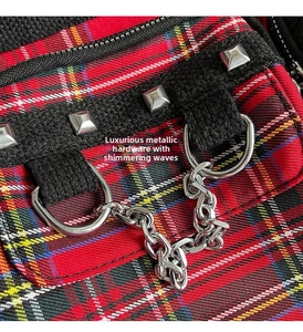 Close-up of punk style plaid tote with silver studs and metal chain details