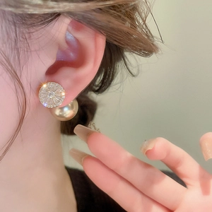 Französische Vintage-Ohrringe mit Zirkonia und Perlen am Ohr eines Damenmodells