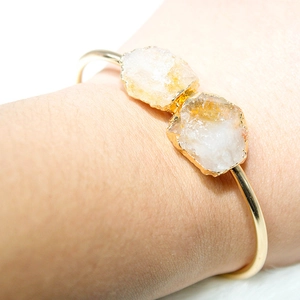 Close-up of gold-plated bracelet with raw yellow citrine clusters on a model's wrist