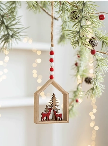 Hanging wooden house Christmas ornament with reindeer and pine tree details on pine branch