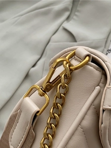 Elegant cream chain bag with quilted leather texture and gold hardware detailing