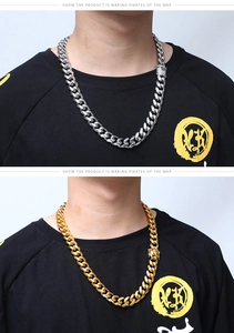 Close-up of thick Cuban link chain necklace with sparkling rhinestone clasp in gold and silver