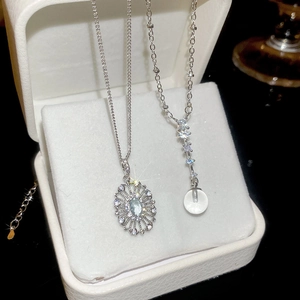 Detail of silver necklace pendants with zircon and cat eye stone in a jewelry box
