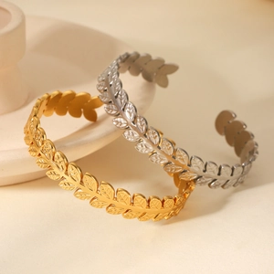 Detailed macro view of adjustable stainless steel laurel leaf bangles in gold and silver