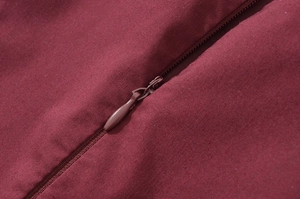 Detailed close-up of dark red woven fabric and invisible zipper on a French vacation dress