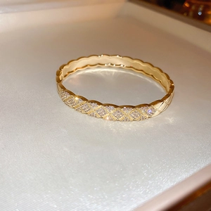 Close-up of gold-plated lattice bracelet with pavé cubic zirconia in a white jewelry box