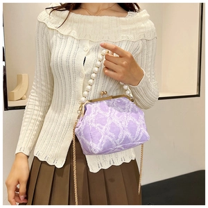 Detail of lavender floral clutch bag with pearl handle and gold chain strap