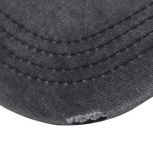 Close-up of distressed dark grey cotton baseball cap brim with three stitching lines