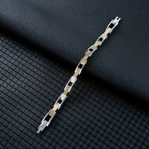 Dettaglio macro del bracciale da uomo bicolore in acciaio con finiture oro e argento