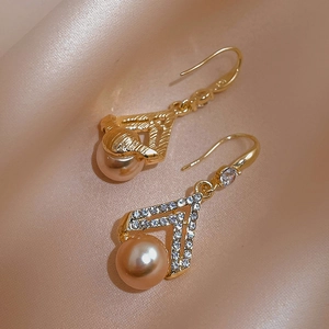 Vintage gold V-shaped drop earrings with crystals and champagne pearl on silk fabric