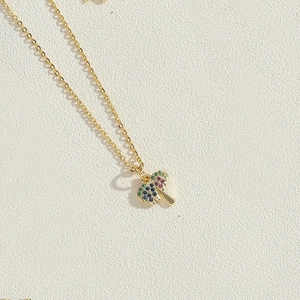 Macro shot of 14K gold plated coconut tree pendant with colorful zircon stones