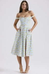 Detail of light blue floral dress with yellow flowers featuring a slit and waist design