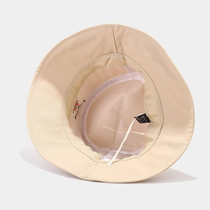 Detail of beige cotton bucket hat interior showing embroidery, stitching and adjustable drawstring