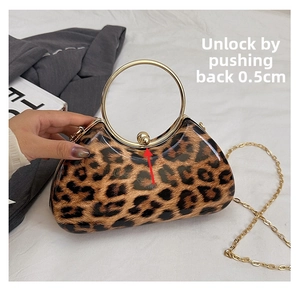 Detail of the push-back metal ball clasp mechanism on a leopard print evening clutch bag