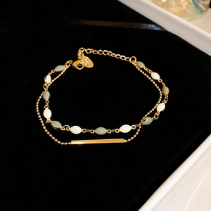Macro shot of double-layer gold chain with marquise beads and S925 stamp on black velvet
