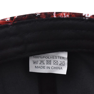Macro detail of washing label and fabric texture inside the red and black baseball cap