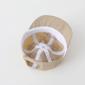 Internal view of khaki baby cap showing breathable lining and adjustable strap detail