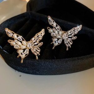 Detailed macro of gold-plated butterfly earrings with sparkling zircons and pearls