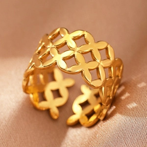 Macro detail of Bohemian gold stainless steel open ring with hollow petal patterns