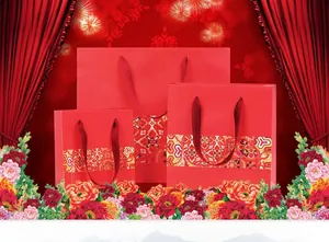 Detailed set of red Chinese ethnic paper gift bags with floral peony patterns and silk handles