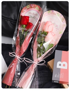 Close-up of romantic floral wrapping sleeves for single roses in red and pink