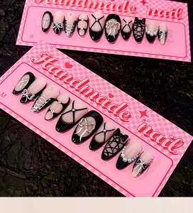 Detail of handmade black and pink almond press-on nails with 3D bows and pearls