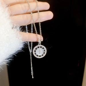 Détail du collier plaqué or 18K avec pendentif croix en nacre et zircon sur le modèle