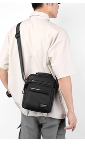 Vertical black nylon crossbody bag for men showing shoulder strap and top handle view