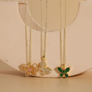 Detailed close-up of butterfly pendants in pink, white, and emerald green with gold chains