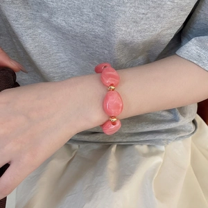 Pink irregular acrylic oval bead bracelet with marble texture and golden spacers