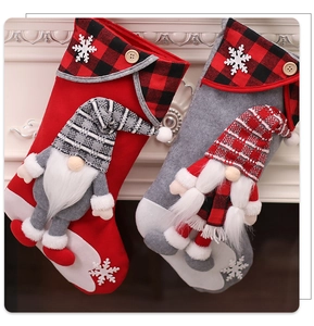 Detail showing two plush Christmas stockings with 3D gnomes on a white fireplace