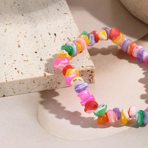 Macro detail of bohemian stretch bracelet with colorful iridescent natural stone beads