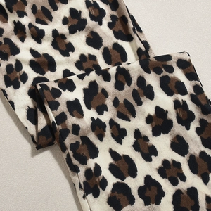 Nahaufnahme des Leopardenmusters auf dem Stoff des körperbetonten Overalls mit Printmuster