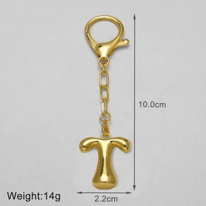 Macro shot of gold 18k letter T keychain pendant with polished mirror finish and lobster clasp
