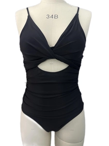 Détail d'un maillot de bain noir avec nœud torsadé, découpe et texture amincissante drapée