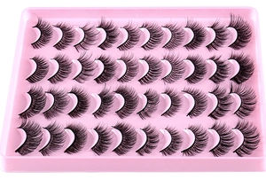 Gros plan de 20 paires de faux cils noirs volumineux avec courbure naturelle sur plateau rose