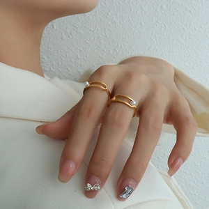 Minimalist gold-plated double-line rings with white pearls on a model's hand