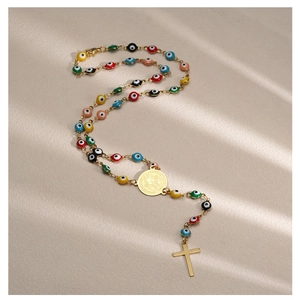 Detailed close-up of a gold rosary necklace with colorful evil eye beads and a Saint Benedict medal