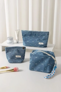 Three-piece denim makeup bag set with white bow and heart patterns for travel