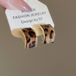 Detail view of vintage leopard print C-shape hoop earrings with gold metal frame