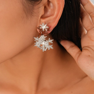 Close-up of a crystal deer earring with brown enamel on a model for Christmas style