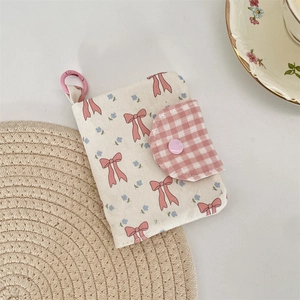 Floral fabric coin purse with pink bow and plaid pattern shown in close-up detail
