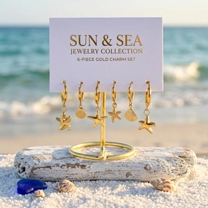 Golden 14K plated marine earrings set with starfish and shell charms on a display stand