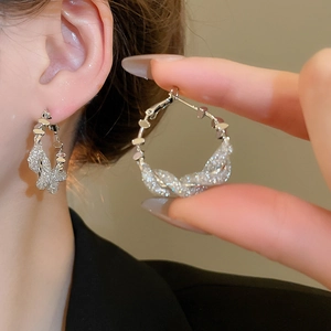 Macro shot of silver knot earrings with pavé zircons and textured metal detail